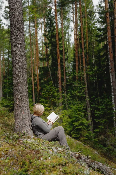 Chica leyendo un libro en el bosque — Foto de Stock