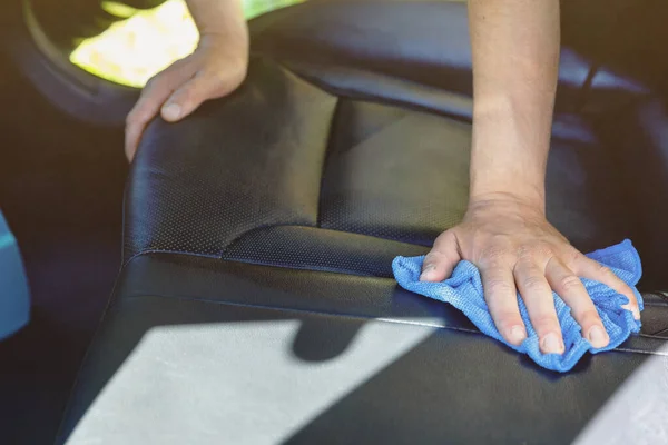 The man is cleaned in the car. rubbing the interior of the car with a rag