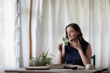 Çiçekçi inek bitkileri kurutur ve hasat eder. Çiçekçinin atölyesinde çalışan kız..