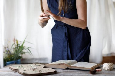 Çiçekçi inek bitkileri kurutur ve hasat eder. Çiçekçinin atölyesinde çalışan kız..