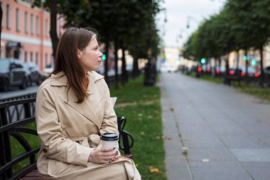 Sokakta tek kullanımlık bardaklı bir kadın.