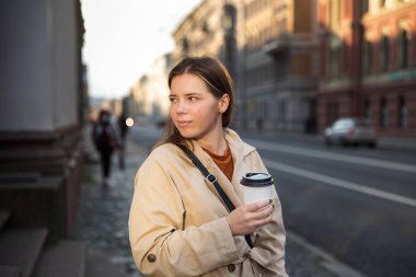 Sokakta tek kullanımlık bardaklı bir kadın.