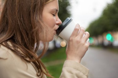 Sokakta tek kullanımlık bardaklı bir kadın.