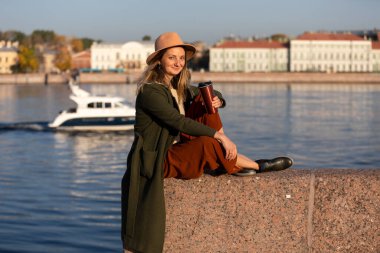 Güneşli bir sabahta bir kız şehirde yürüyor.