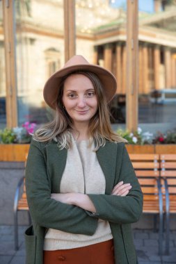 Güneşli bir sabahta bir kız şehirde yürüyor.