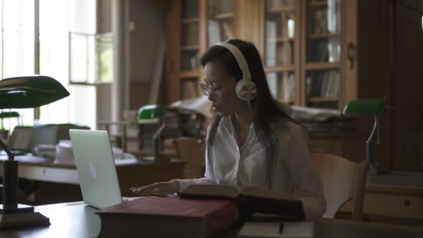 Asijská studentka v kulaté brýle, poslechu hudby