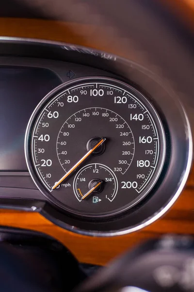 Klasik analog hız göstergesi krom ve ahşap süslemeli lüks modern arabada saatte kilometrelerce hız gösteriyor.