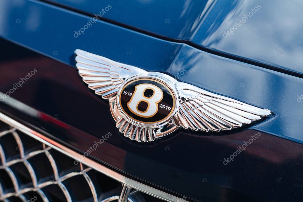 Vilnius, Lithuania - 2025-09-09 - Bentley Bentayga blue SUV with hood emblem showing anniversary logo 1919-2019