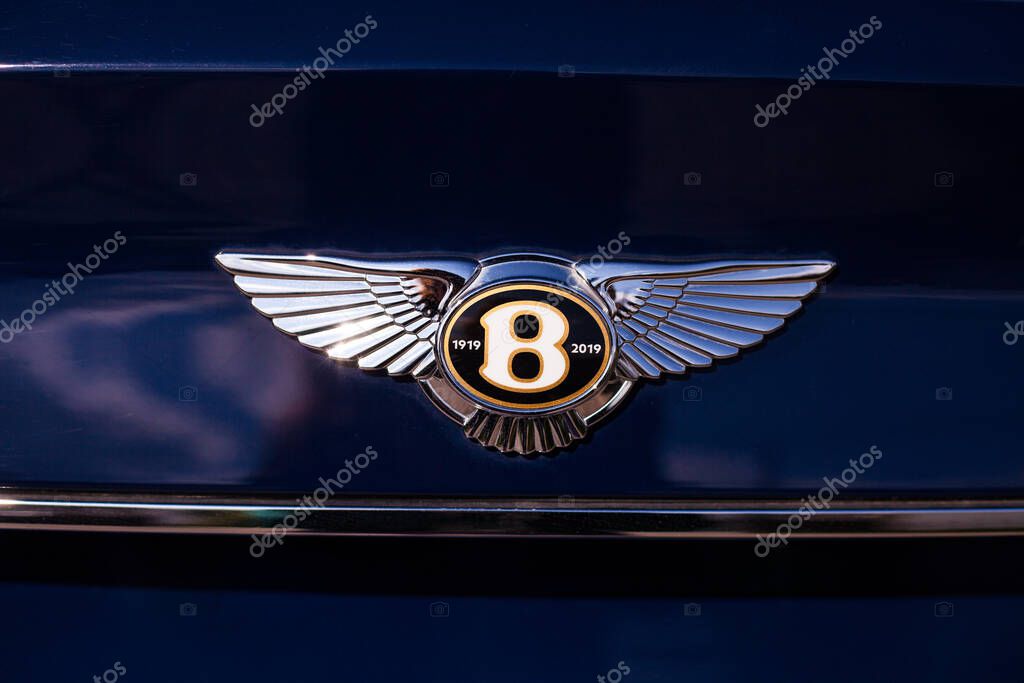 Vilnius, Lithuania - 2025-09-09 - Bentley Bentayga blue SUV with hood emblem showing anniversary logo 1919-2019