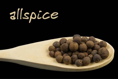 Tahta kaşık siyah arka plan üzerine izole yenibahar