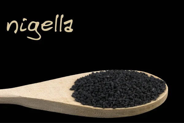 Nigella Auf Holzlöffel Isoliert Auf Schwarzem Hintergrund — Stockfoto