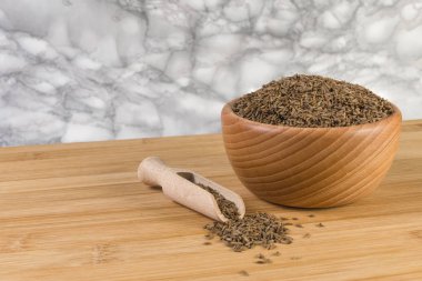 Kimyon tohumları ahşap kepçe ve kase bambu masa üzerinde. Üstten Görünüm.