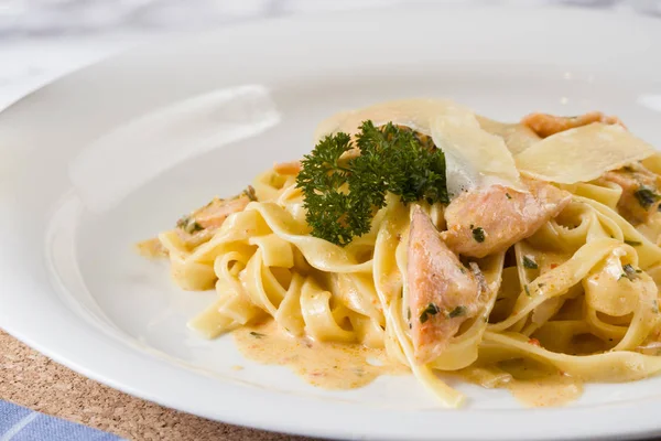 Delicious salmon pasta dish, tagliatelle noodles with Parmesan and parsley.