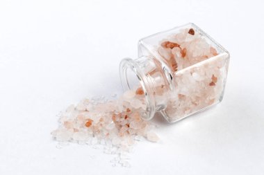 Beyaz arka plan üzerinde izole bir cam kavanoza pembe Himalaya tuz