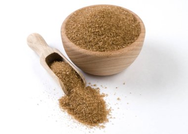 Ahşap kase ve kepçe beyaz arka plan üzerinde izole kahverengi veya baston şeker. Baharatlar ve gıda maddeleri.