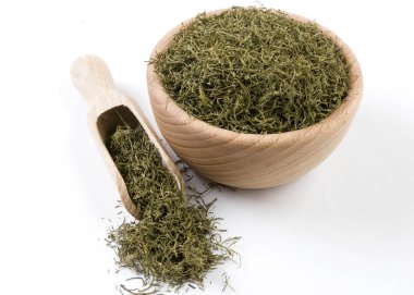 ahşap kase ve beyaz arka plan üzerinde izole Kepçe dereotu. Baharat ve Gıda katkı maddeleri.