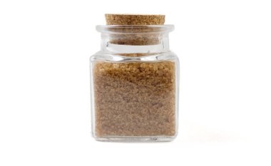 Beyaz arka plan üzerinde izole cam kavanozda kahverengi veya baston şeker. ön görünüm. baharatlar ve gıda maddeleri.