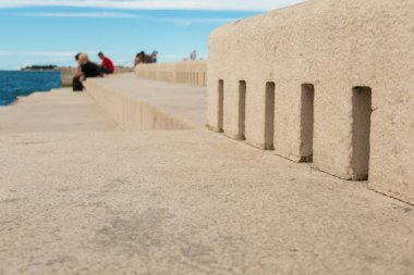 Hırvatistan 'ın Zadar kentinde yer alan bir mimari ses sanatı olan Sea Organ' ın yanında oturan insanlar.