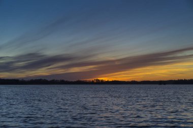 Bahar akşam İsveç İskandinavya Avrupa'nın güzel doğa ve manzara fotoğraf. Güzel taze mavi alacakaranlıkta gökyüzü günbatımı. Göl yansımaları, ahşap köprü ve ağaçlar ufuktan. Sakin, huzurlu fotoğraf