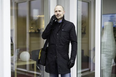 Adam akıllı telefon açık havada üzerinde konuşurken siyah giysili 