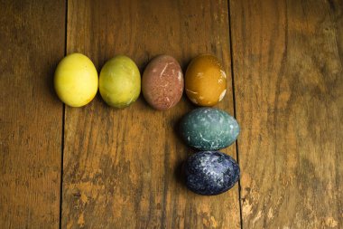 Güzel doğal renkli Paskalya yumurtaları ahşap masa üzerinde. Renk yalnızca doğal maddeler ile ham organik gıda. 
