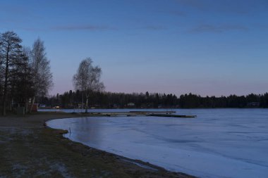 Renkli mavi ahşap köprü ile gölde kış manzara akşam