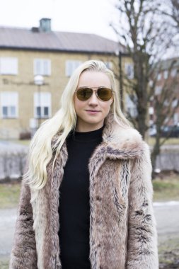 Açık havada giyen kürk ceket poz güzel sarışın genç kadın 
