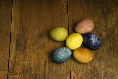 Güzel doğal renkli Paskalya yumurtaları ahşap masa üzerinde. Renk yalnızca doğal maddeler ile ham organik gıda. 