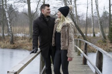 İsveççe köprü üzerinde açık duran genç çift doğa manzara kış