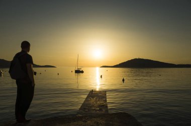 Adam ayakta Hırvatistan Adriyatik Denizi günbatımında kapatın. 