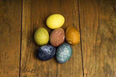 Güzel doğal renkli Paskalya yumurtaları ahşap masa üzerinde. Renk yalnızca doğal maddeler ile ham organik gıda. 