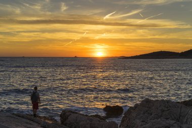 Adam ayakta Hırvatistan Adriyatik Denizi günbatımında kapatın. 