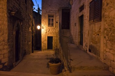 Şehir, Sibenik Hırvatistan Avrupa gece. Sıcak güzel yaz geceleri sarı ve kırmızı renk tonları ile. Küçük sokaklar evler ve binalar güzel akşam arasında. Taş zemin ve duvarlar