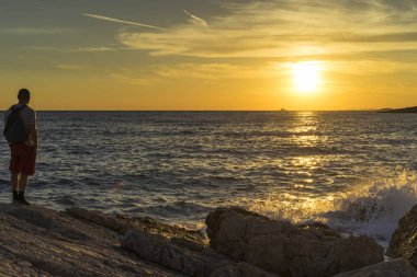 Adam ayakta Hırvatistan Adriyatik Denizi günbatımında kapatın. 