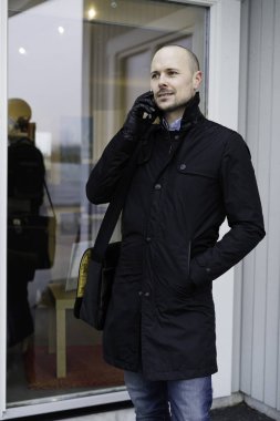 Adam akıllı telefon açık havada üzerinde konuşurken siyah giysili 