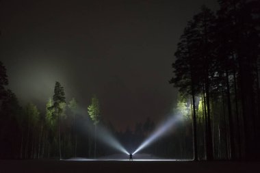 Adam açık havada ağaç arka sokakta el feneri ile parlayan geceleri ayakta. Güzel koyu karlı kış gecesi.