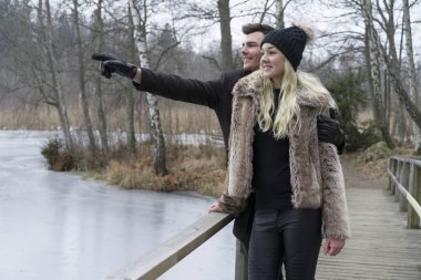 İsveççe köprü üzerinde açık duran genç çift doğa manzara kış