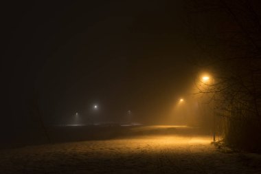 İsveç İskandinavya Avrupa'nın sisli geceler. Sis hava ile karanlık kış akşam güzel, mistik ve soyut fotoğraf. Sakin, huzurlu açık havada resim ışıklar, lambalar ve yol.