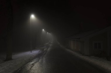 İsveç İskandinavya Avrupa'nın sisli geceler. Sis hava ile karanlık kış akşam güzel, mistik ve soyut fotoğraf. Sakin, huzurlu açık havada resim ışıklar, lambalar ve yol.
