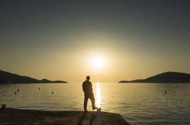 Adam ayakta Hırvatistan Adriyatik Denizi günbatımında kapatın. 