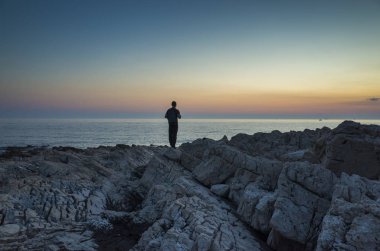 Adam ayakta Hırvatistan Adriyatik Denizi günbatımında kapatın. 