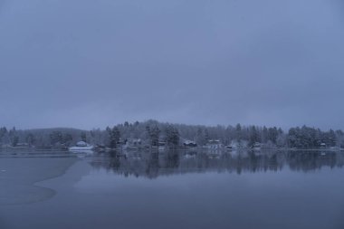 Güzel doğa ve manzara fotoğraf mavi akşam Katrineholm İsveç İskandinavya. Orman ve göl kar ve buz ile.
