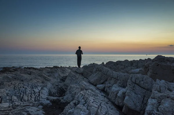 Adam ayakta Hırvatistan Adriyatik Denizi günbatımında kapatın. 
