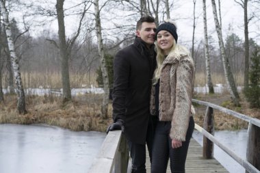 İsveççe köprü üzerinde açık duran genç çift doğa manzara kış