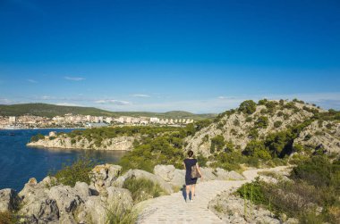 Kanal, St Anthony, Sibenik, Hırvatistan. Güzel güneşli bir günde Dalmaçya, açık havada güzel ve sıcak yaz sezonu manzara fotoğrafı, Adriyatik Denizi. Sakin, huzurlu ve mutlu görüntü. Açık yürüyen kadın