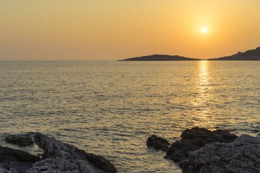 Güzel manzara ve doğa fotoğraf gün batımı Hırvatistan Avrupa'nın Adriyatik denizde. Güzel renkli açık havada resim. Okyanus, kayalar ve akşam gökyüzüne sakin, huzurlu resmi.