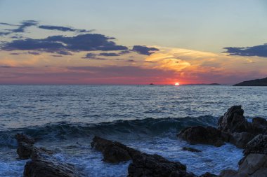 Güzel manzara ve doğa fotoğraf gün batımı Hırvatistan Avrupa'nın Adriyatik denizde. Güzel renkli açık havada resim. Okyanus, kayalar ve akşam gökyüzüne sakin, huzurlu resmi.