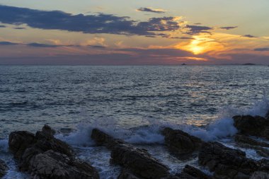 Güzel manzara ve doğa fotoğraf gün batımı Hırvatistan Avrupa'nın Adriyatik denizde. Güzel renkli açık havada resim. Okyanus, kayalar ve akşam gökyüzüne sakin, huzurlu resmi.