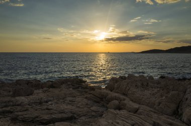 Güzel manzara ve doğa fotoğraf gün batımı Hırvatistan Avrupa'nın Adriyatik denizde. Güzel renkli açık havada resim. Okyanus, kayalar ve akşam gökyüzüne sakin, huzurlu resmi.