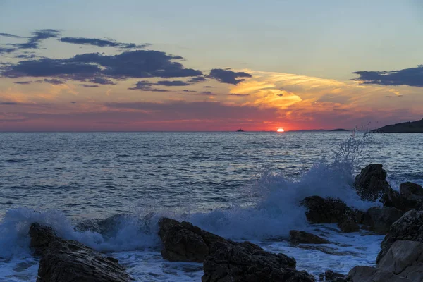 Güzel manzara ve doğa fotoğraf gün batımı Hırvatistan Avrupa'nın Adriyatik denizde. Güzel renkli açık havada resim. Okyanus, kayalar ve akşam gökyüzüne sakin, huzurlu resmi.
